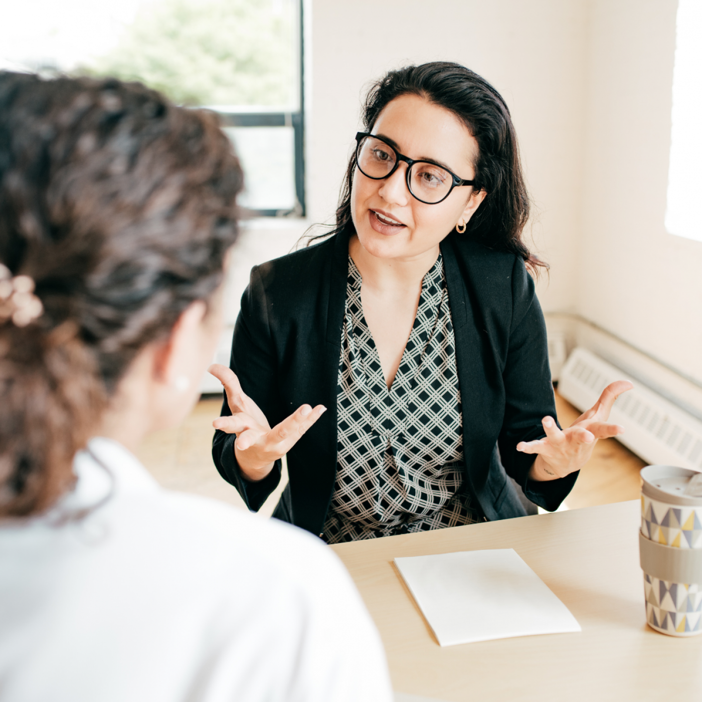 Workshops & Webinare Ein Foto von einer Frau die einer anderen Person etwas erklärt.